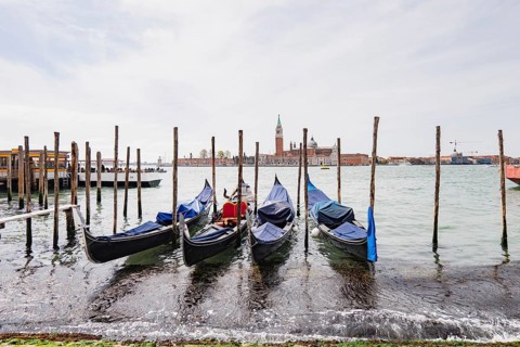 Stunning architecture of Venice, Italy, with gondolas lining the serene canal. This picturesque