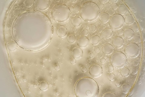 Close-up image capturing the intricate texture of oil bubbles suspended on a translucent glass