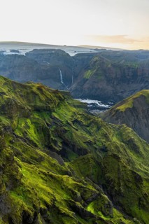 Moss-covered mountains at sunset, waterfalls on a cliff at Myrdalsjökull glacier, Pakgil, Iceland
