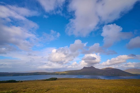 Tranquil landscape with a lake surrounded by hills under a cloudy blue sky, Little Loch Broom, view