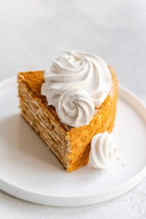 Tempting homemade honey cake topped with a luscious sour cream sauce and elegantly adorned with