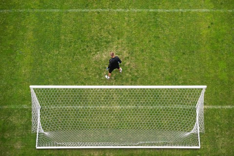 Soccer goalkeeper in front of goal - view from above