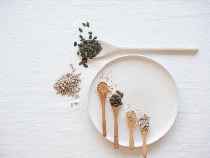 Different seeds on spoons and plate, promoting natural hormone balance
