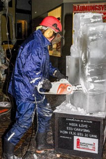 An ice sculpture is being created: ice carving street action as part of the long shopping night in