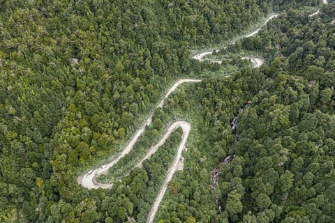 Aerial view of a winding road (Carretera Austral) through dense forest, south of Puyuhuapi, Aysén