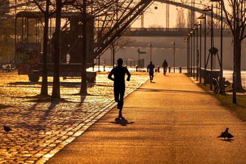 Joggers run along the banks of the Main in Frankfurt in the morning just after sunrise, Frankfurt
