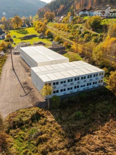 Commercial building in a small mountain village surrounded by autumnal trees, refugee accommodation