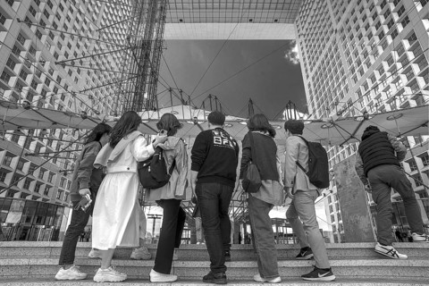 Tourists take a souvenir photo in the Grand Arche, La Défence, the New High City Quarter, black and