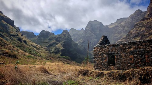 Ruins of volcanic stone in a dramatic mountain setting with clouds in the sky, hiking, lost place,