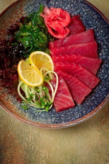 Tuna sashimi with daikon and wakame salad, pickled ginger, in a bowl