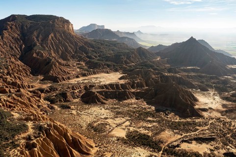 Captivating aerial view of a rugged mountain landscape featuring dramatic peaks and deep valleys