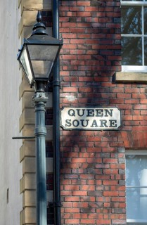 Historic lamppost and street sign on red brick Georgian building, Queen Square, Bristol, England,