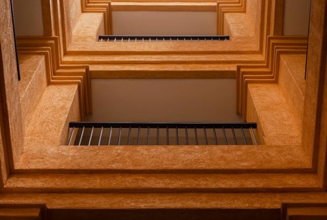 This image captures a unique perspective of geometric architectural layers and balconies. The warm