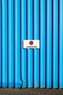 Loading zone sign on a blue wall of a commercial building in the eastern harbour, Frankfurt am