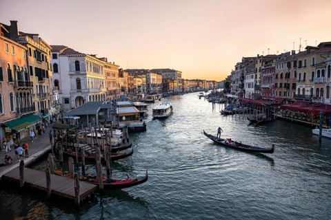 View of the Grand Canal with gondoliers at sunset, picturesque evening mood with palazzos on the