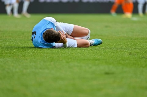The injured footballer lies on the pitch in Lubin, Poland
