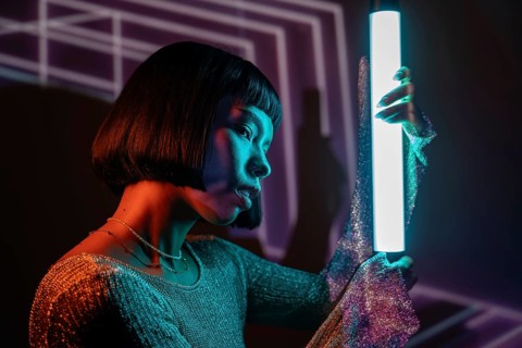 A futuristic Latin woman is immersed in a vibrant metaverse, surrounded by neon lights and digital