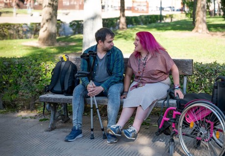 A college couple sitting on a bench embraces inclusivity and disability awareness The woman,