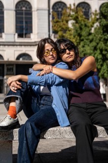 A tender scene of a multiethnic lesbian couple enjoying a shared moment outdoors. Their embrace and