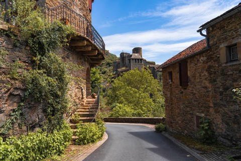 A picturesque Chateau Brousse castle medieval road in france with rustic stone houses, lush