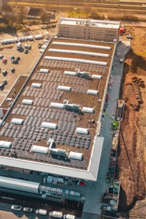 Industrial buildings with solar panels and construction machinery in an urban landscape, PV Bau Auf