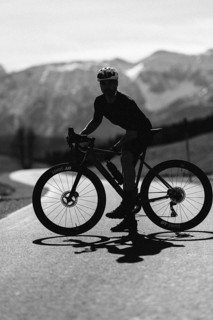 Road bike rider in spring near Halblech in the Allgäu in front of a picturesque backdrop of the