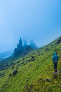 UK. Scotland. Isle of Skye. A tourist looking at the Old Man of Storr during a storm