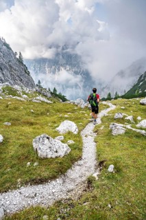 Mountaineer on a hiking trail, cloudy mountains, descent over the Ofental, mountain tour on the