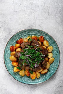 Kuyrdak, roast offal with potatoes and fresh herbs, homemade in Kazakh, no people