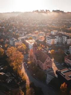 Church in the middle of an urban landscape at sunrise with autumnal colours, Nagold, Black Forest,