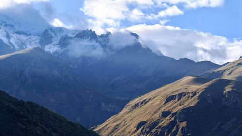Majestic mountain landscape with clouds and sunlight in the background, Kazbek, Stepantsminda,