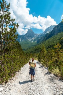 Woman hikers walking in Valbona valley next to trees, Theth national park, Albanian Alps, Albania