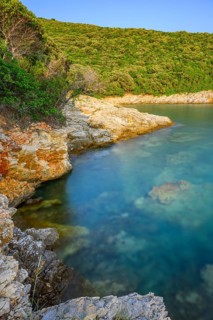 Crystal clear and turquoise water on the beach of Ustrine Bay on a sunny day at sunset on the