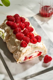 Delight in a luscious raspberry meringue roulade, filled with whipped cream and topped with fresh