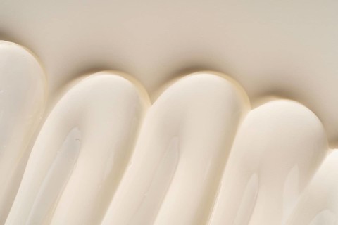 A close-up of a creamy cosmetic gel texture in soft, curved waves creates a soothing and elegant