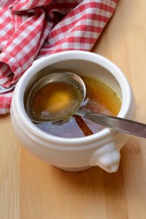 Bouillon, beef broth with ladle in bowl