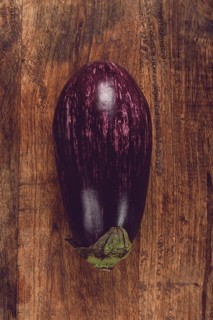 Purple and white eggplant, on a wooden chopping board, top view, raw eggplant, no people