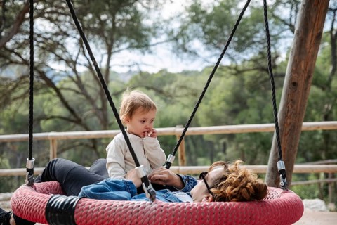 A mother and her daughter relax in a park in the forest during a peaceful afternoon. Surrounded by
