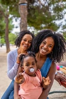 Vertical frontal cute portrait of three generation african woman in the park