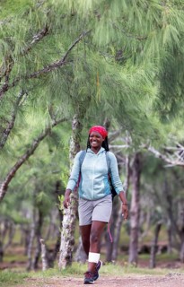 Mauritian woman, 35 years old, laughing, walking through a casuarina forest, Rodrigues Island,