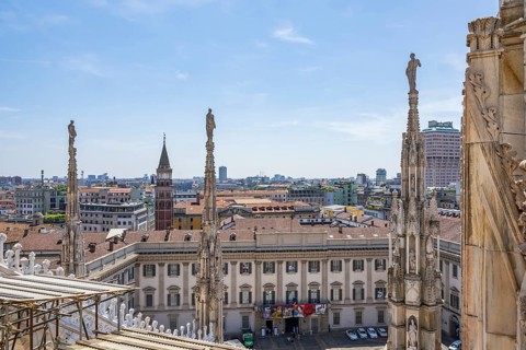 Sculptures of saints gaze down on the city from Milan Cathedral on a sunny day, Milan, Italy