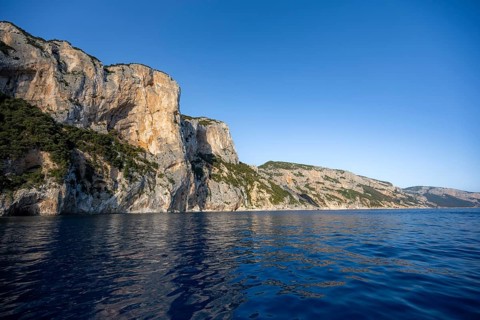 Picturesque rocky coast, cliffs in morning light, blue sea, Golfo di Orosei, Baunei, Sardinia,