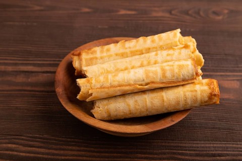 Waffles with caramel on brown wooden background, side view, copy space