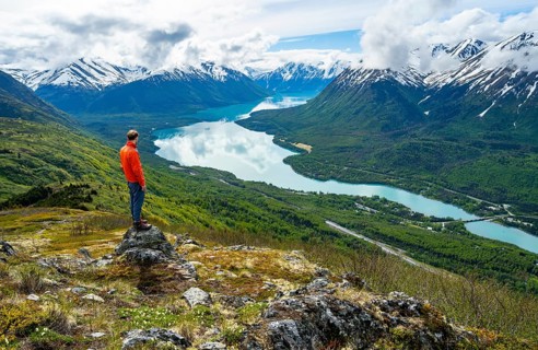 Climber enjoying the view, Slaughter Ridge Trail, view of snowy mountains and turquoise blue Kenai