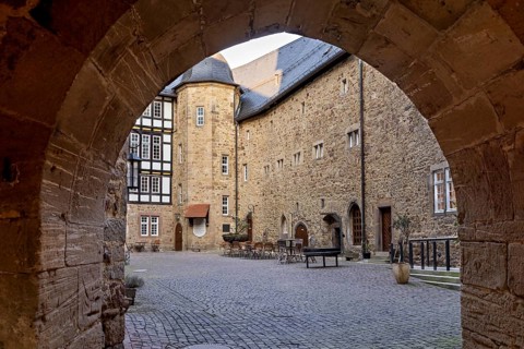 View through a Tor tor to a historic courtyard with half-timbering and stone walls, The courtyard