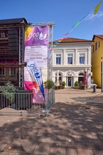 Stage with programme for the 900th anniversary celebrations and pastel-coloured houses with pointed