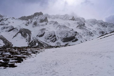 Snowy mountain landscape with rugged rock peaks, clouds and diffuse backlight, Martial Mountains,