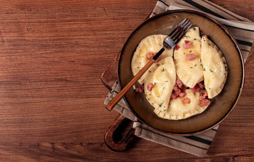 Dumplings, with fried prosciutto, a traditional dish of Polish cuisine, dumplings, top view,