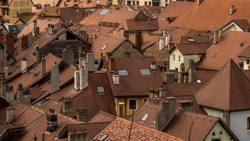 An aerial shot capturing a maze of interlocking terracotta rooftops and chimneys in Annecy, France,