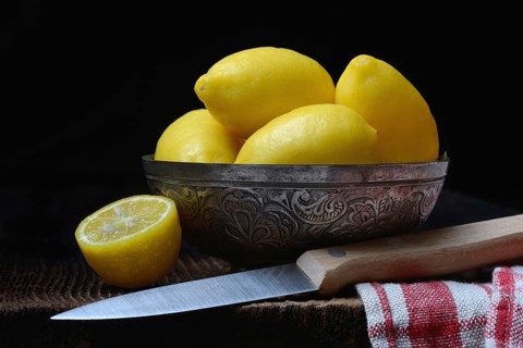 Mini lemons in peel with knife, lemon snack, snack lemon